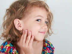 When and in what way is it better to pierce the ears of a child?