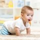 At what age does the child begin to crawl, and what exercises contribute to this?