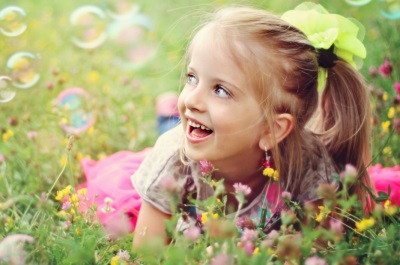 Girl with soap bubbles on the field