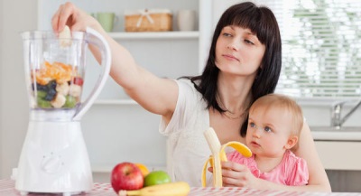 Mom with baby, food in a blender