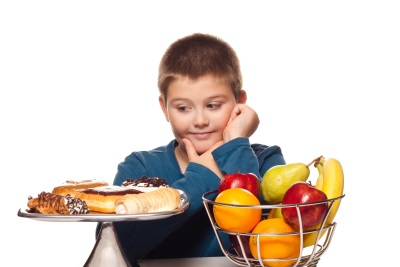 Schoolboy with sweet and fruit