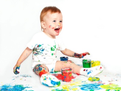 A child of 1.5 years playing with paints