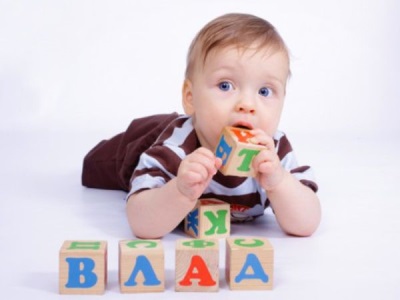 A 6 month old child pulls a toy into his mouth