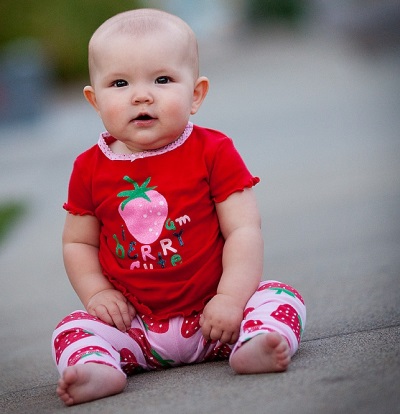 Girl sits at 9 months