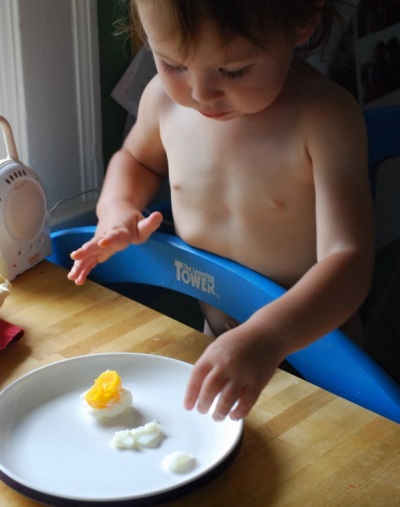 Baby eating egg