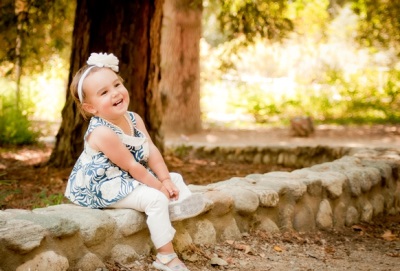 Girl 2 years old sits on a log