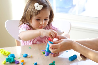 Girl sculpts from dough for sculpting on a mug